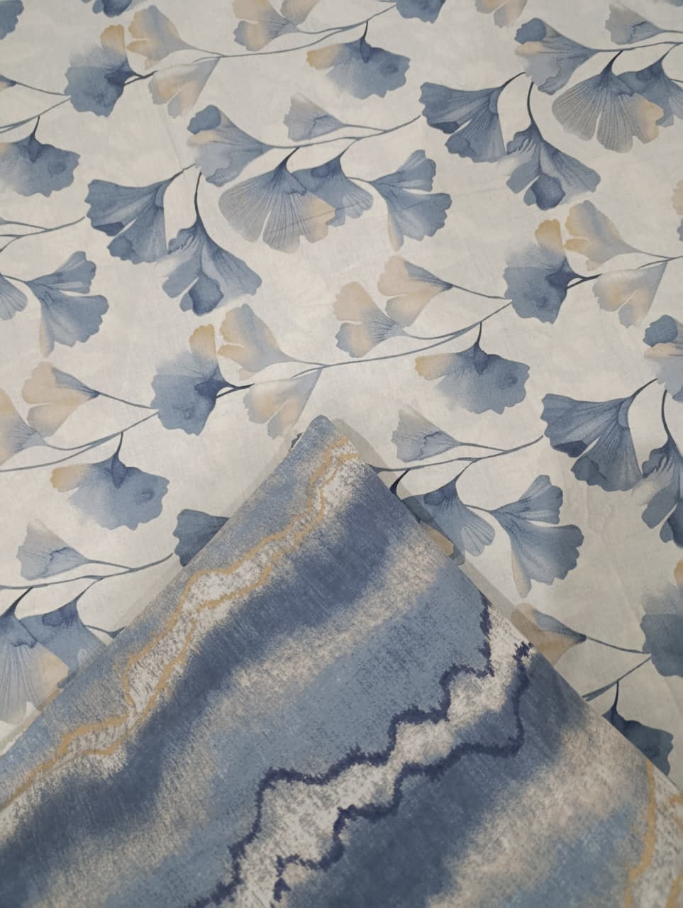 Floral patterned fabric with blue and beige leaves on a neutral background