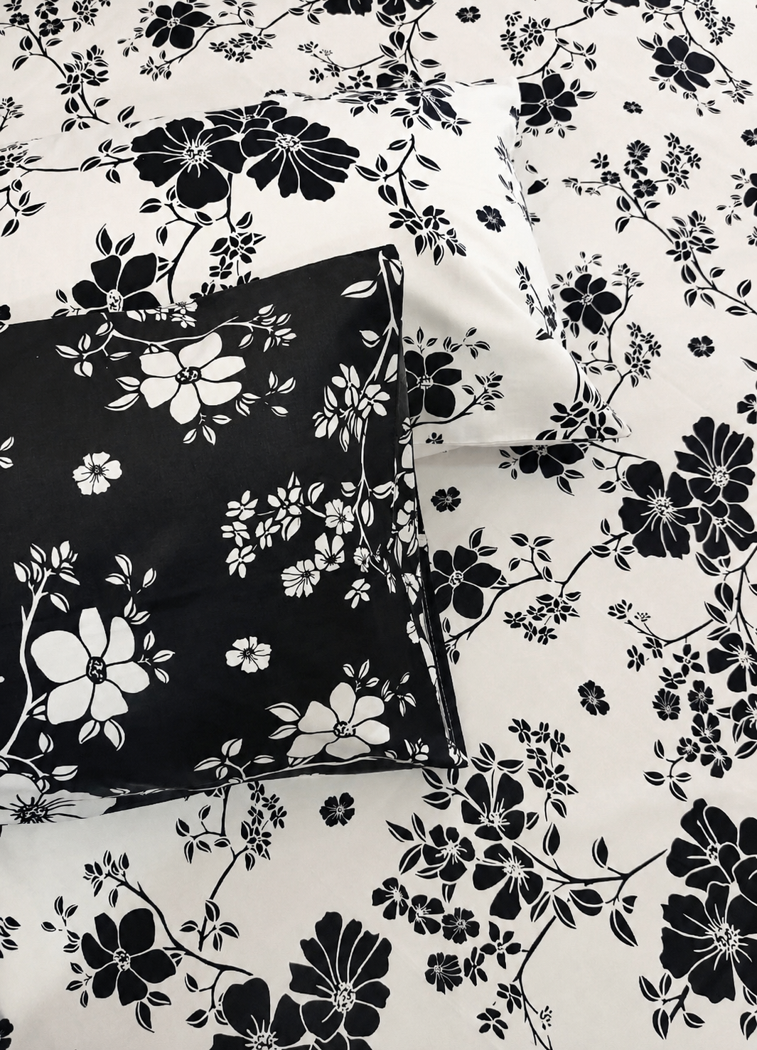 Black and white floral bedding set featuring a duvet cover and matching pillowcase with a bold black floral print on a white background.